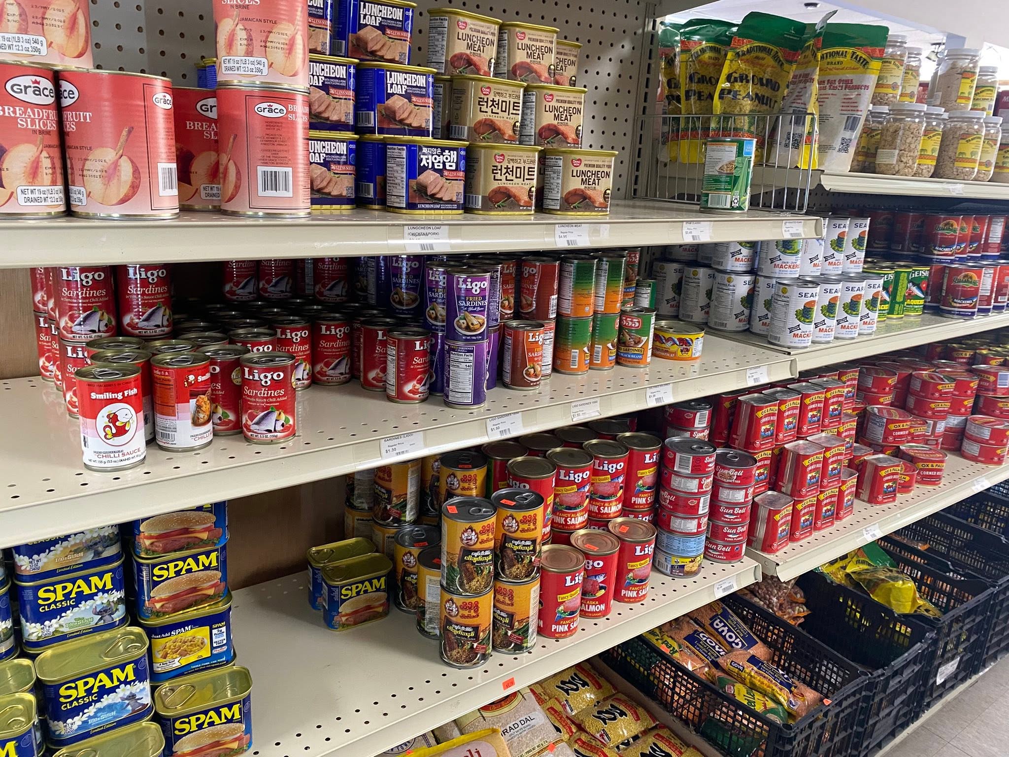 A stocked shelf of canned foods and pantry products at S International Market